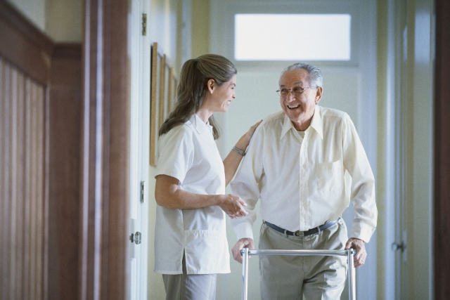 A nurse and an old man in a hallway